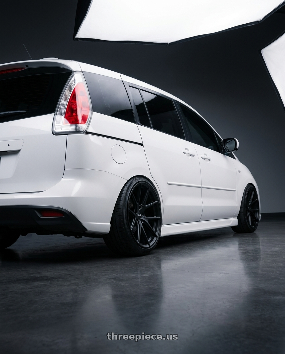 2010 Mazda 5 with Bravado 08B Tribute 5x114.3 19x9.5 +35 Matte Black wheels rear three quarter view slight stretch tires