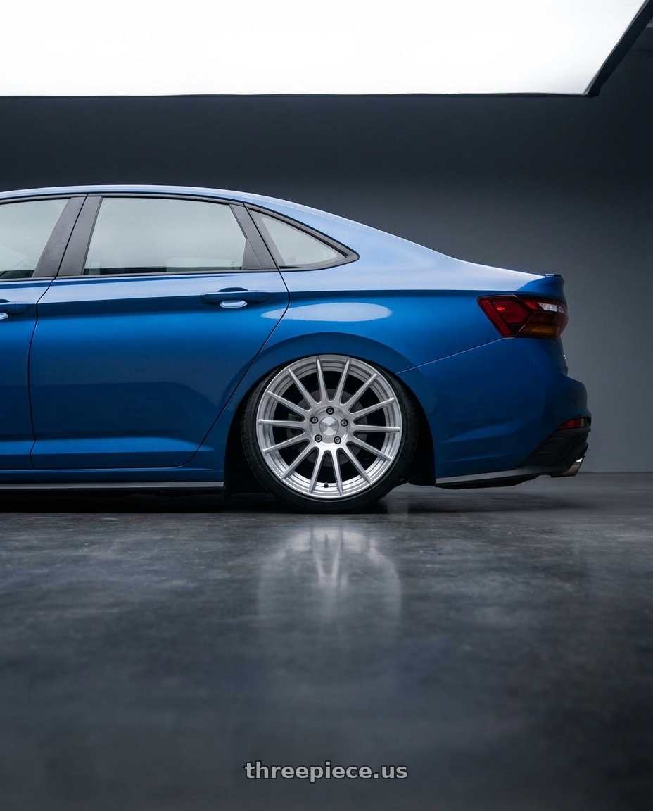 2024 Volkswagen Jetta gli blue with Rotiform 1PC R120 SPF 5X112 19X8.5 +45 GLOSS SILVER MACHINED wheels rear three quarter view slight stretch tires