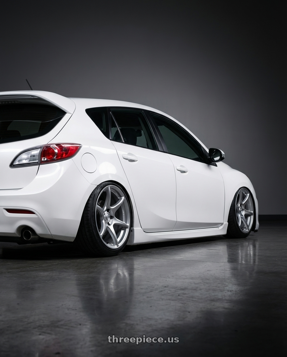 2012 Mazda Mazdaspeed3 with Kansei K11S Tandem 5x114.3 18x10.5 12 Hyper Silver wheels rear three quarter view slight stretch tires