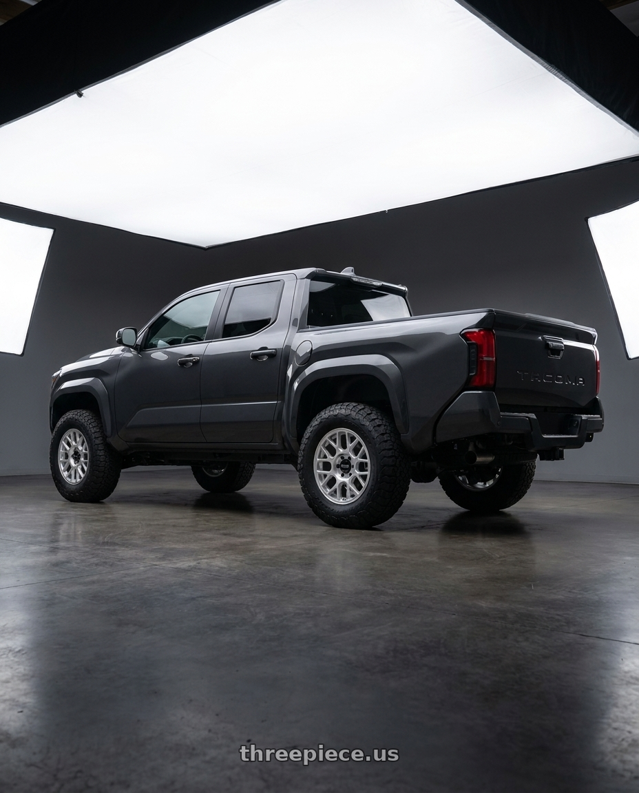 toyota tacoma 4th gen 2024 sr rwd with KMC KM730 HATCHET 6X139.7 17X8.5 -10 GLOSS SILVER W/ MACHINED FACE wheels rear three quarter view meaty tires