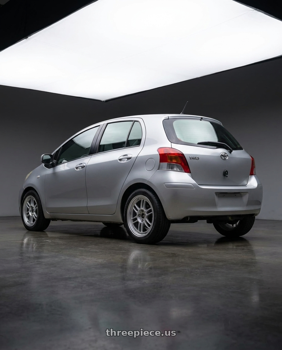 2010 toyota Yaris with Enkei RPF1 4x100 16x7+35 Silver wheels rear three quarter view square tires